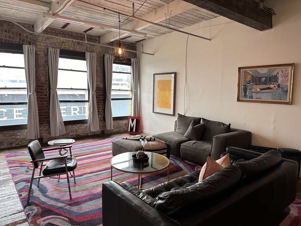 Lounge corner with sofas, a colorful rug and art on the walls